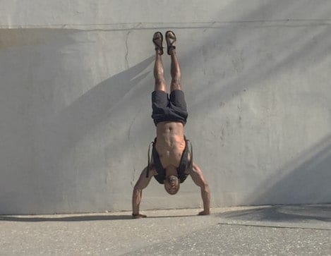 Handstand pushups with added weight in the GORUCK GR3 from a water jugs or weights are the perfect exercise for shoulders and arms