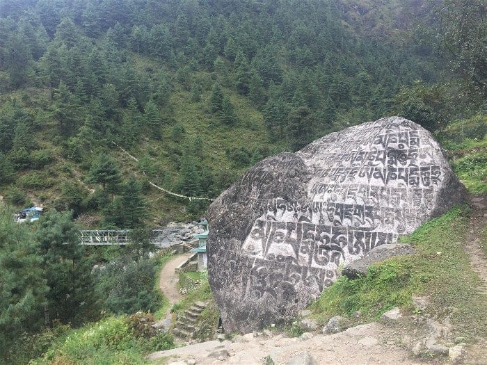 Humongous rocks throughout the trail stand as a religious scripts between hamlets on the road from Lukla to Phakding