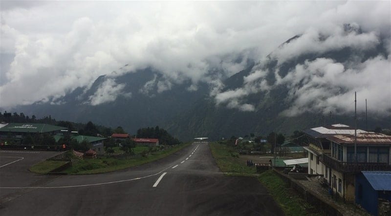 This picture displays a plane taking off just before the end of the 527-meter-long Lukla Airport runway and the steep drop at the end. The short, terrain confined runway and steep drop off complicate potential emergency options for pilots during takeoff